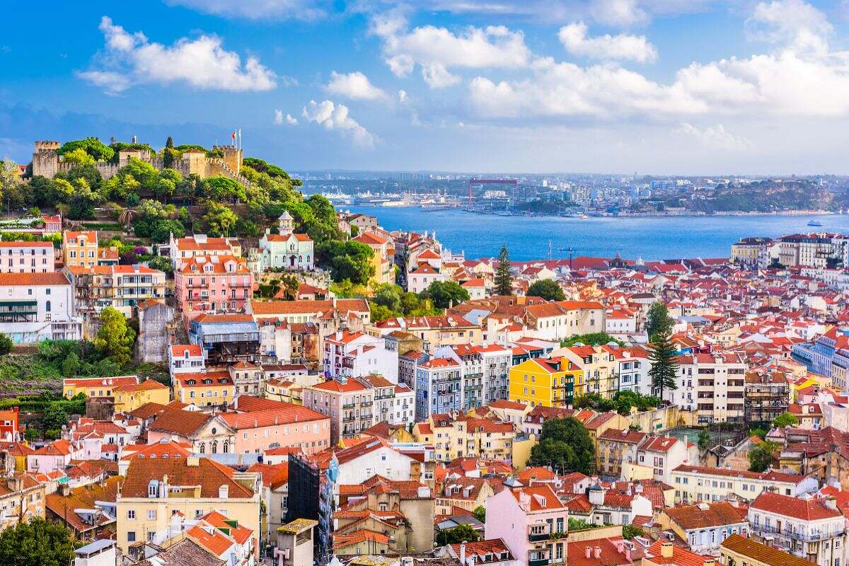 En vy över Lissabon i Portugal med många hus, kullar och vatten.