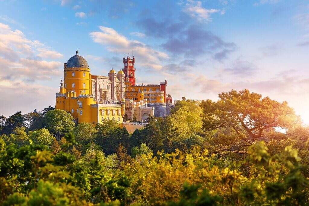 Sagolikt vackra Palace of Pena med sina färgglada torn, bakom en vacker skog i Lissabon, Portugal.