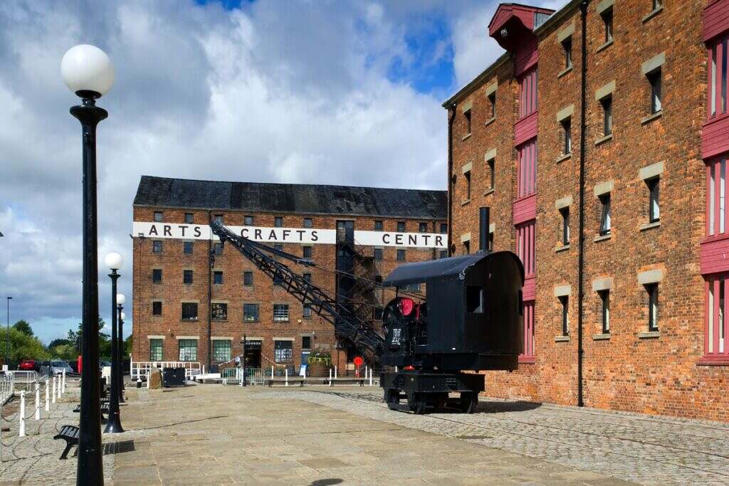 Två lager av röda tegelhus och en äldre lyftkran i Albert Docks i Liverpool.