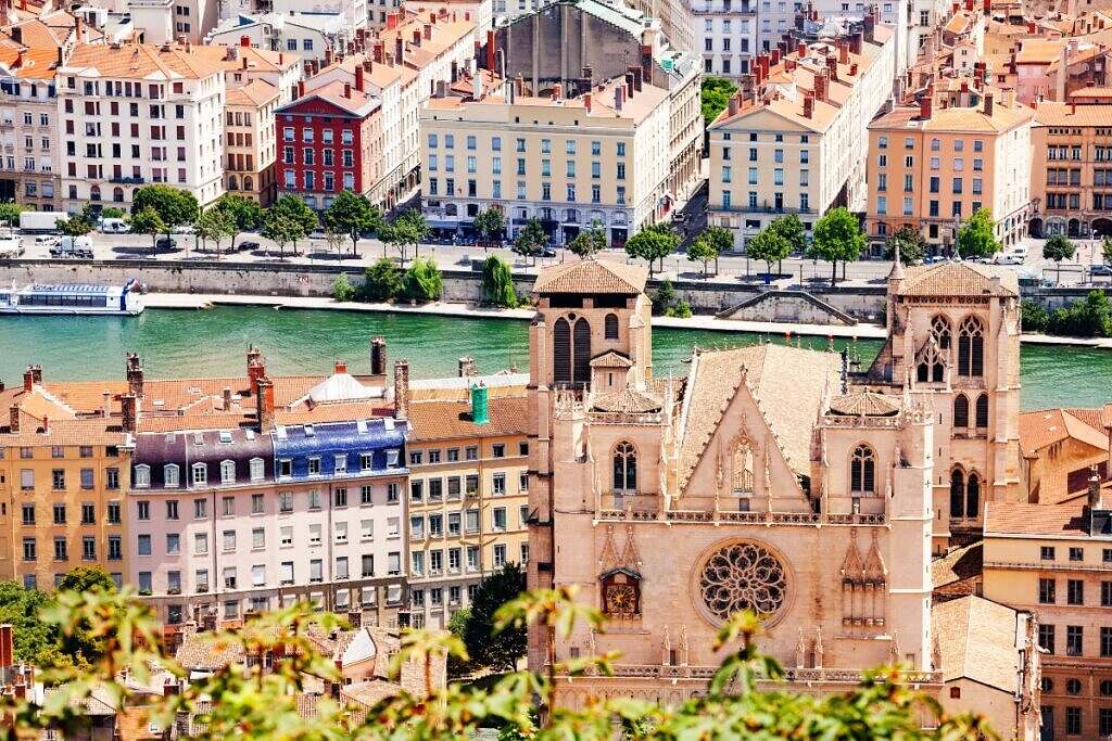 Vackra äldre bostadshus och en kyrka utmed floden Saône i Lyon, Frankrike.