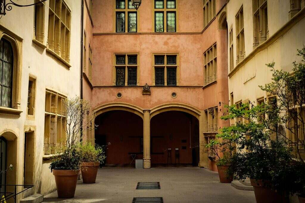 En vacker, gammal innergård med äldre hus i gul och orange färg i Lyon, Frankrike.