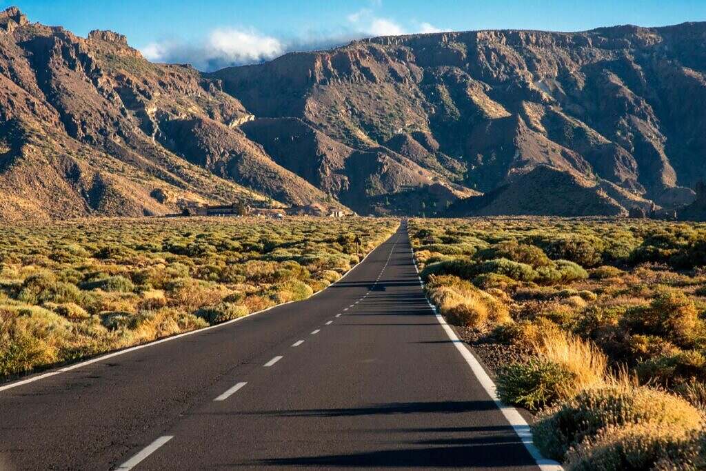 En rak väg leder ut mot vildmarken i bergen på Teneriffa i Spanien.